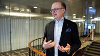En man viftar med händerna framför en trappa.