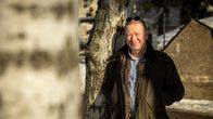 Helsingin yliopiston Lähi-idän tutkimuksen professori Hannu Juusola nojaa koivupuuhun Yleisradion pihalla.
