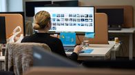 A woman sits at a computer. 