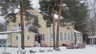 En vit träbyggnad på vintern.