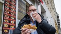 Miehellä döner kebab kädessään.