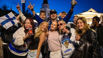Iso joukko nuoria poseeraa yhteiskuvassa Keskustorin yössä.