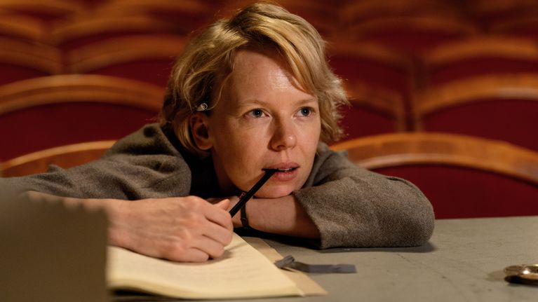 Tove (Alma Pöysti) sitter vid scenkanten och ser fundersam ut. 