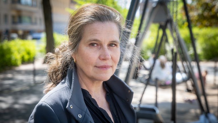 Anna Rotkirch står framför några gungor, där några barn gungar.