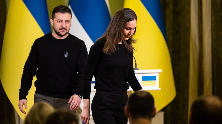 Finnish Prime Minister Sanna Marin and Ukrainian President Volodymyr Zelensky in front of Ukrainian and Finnish flags at a press conference. 