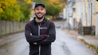 En man i sportjacka och keps ler mot kameran.