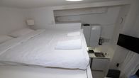 Photo shows a small apartment with the bed on a mezzanine.