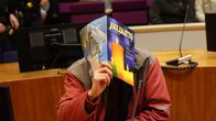 Henkilö piilottaa kasvonsa Jouluaatto-lehdellä oikeussalissa.