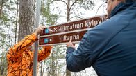 Työntekijät asentavat opastekylttejä retkeilyreitille Imatran kylpylän ja Rauhan suuntaan.