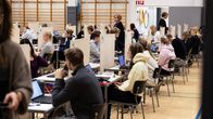 Abiturientit istuvat valmistautumassa ylioppilaskirjoituksiin. 