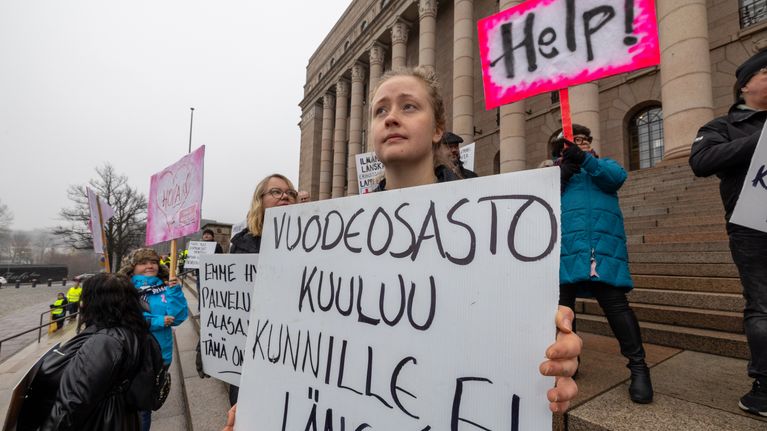 Iitu Kinos kyltti kädessä.