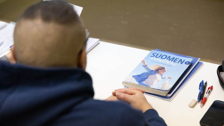 Suomen kielen kurssi maahanmuuttajille Haminassa. Pöydällä on Suomen Mestari 1 oppikirja.