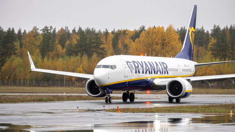 Ryanairin lentokone kiitotiellä syksyisessä maisemassa.