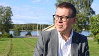 En man med glasögon kisar mot solen.