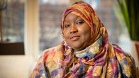 Värikkääseen huiviin pukeutunut Amal Abdi Ibrahim katsoo kameraan.