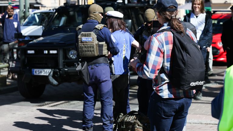 Poliisit ottavat kiinni mielenosoittajan.