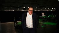 Tmo Soini står i ett funkelt och ganska tomt rum med namnlapp kring halsen.