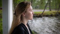 Kateryna Prochukhan seisoo huvimajassa järven rannalla.