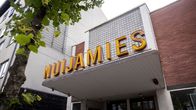 Nuijamies -kyltti vanhan elokuvateatterin oven yläpuolella.