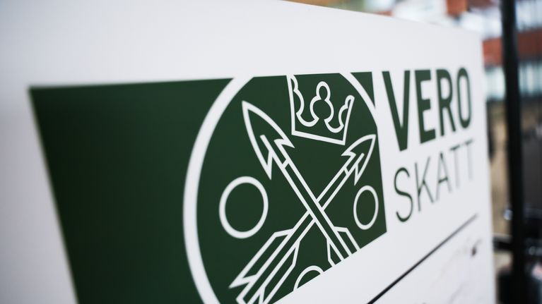 Valkoinen kyltti, jossa verohallinnon logo ja vihreällä teksti Vero Skatt.