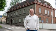 Theodor Steidel står i ljus tröja och jeans framför Lovisa gamla polishus, en gammal byggnad i rödtegel.