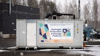 Metallinen kontti lumisateessa. Kontti on tehdasalueen pihalla.