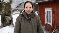 Niina Männistö ulkona punaisen mökin edessä talvella.