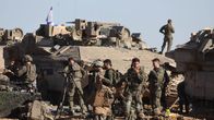 Israeli soldiers stand next to their military vehicles near the border fence with the Gaza Strip.