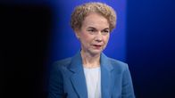 Turkoosiin jakkuun pukeutunut Kristi Raik istuu Ykkösaamun studiossa. Etualalla näkyy osa studiokamerasta tummana ja tausta on sininen.
