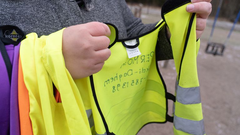 Kvinna håller upp reflexväst.