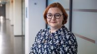 Anna Sorjonen seisoo käytävällä ja katsoo kameraan.