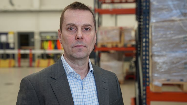 Tommi Koivusalo, elinvoimajohtaja, Vantaa seisoo ammattiopisto Varian varasto-opetustilassa kameraan katsoen.
