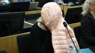 Kvinnan, som dömts till utsättande för att inte tagtit hand om sitt barn så det dog, sitter med jacka över huvudet.