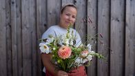 Siuntiossa sijaitsevan Monosen puutarhan (Monosilla Garden) kukkatarhuri Sannaliina Mononen kädessään vasta kerätty kimppu Slow Flowers -filosofialla kasvatettuja avomaan leikkokukkia, 9.8.2022.