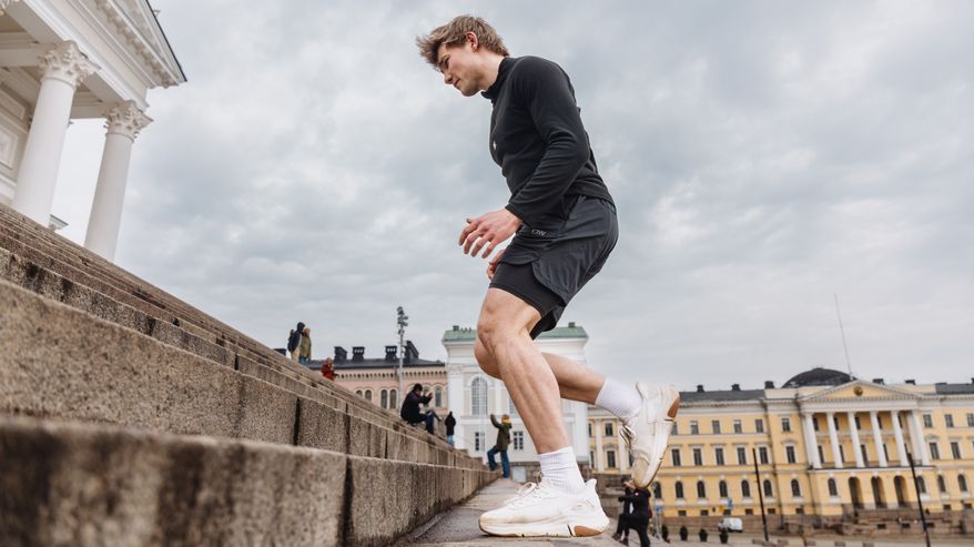 Mies juoksee portaita ylös Senaatintorilla Helsingissä.