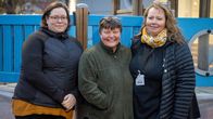 Tre kvinnor med ytterkläder står ute, utanför ett daghem (som inte syns)