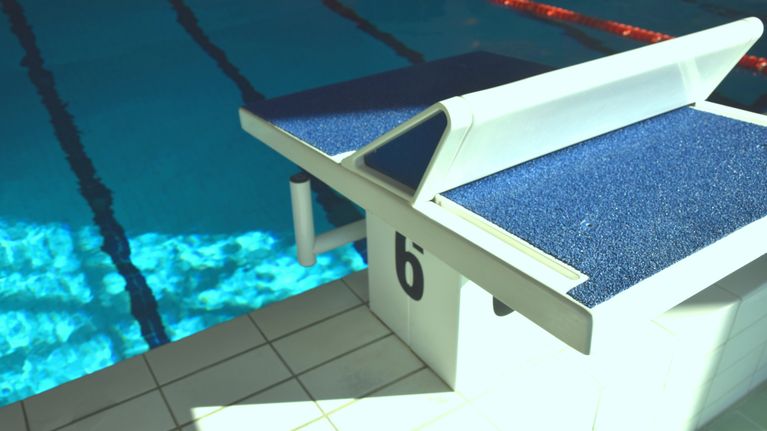 Hoppavsats i simhall intill bassäng.