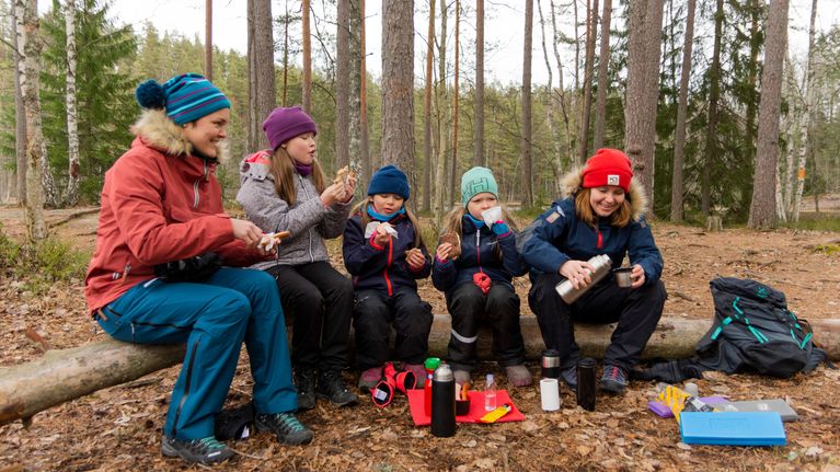 Retkeilijöitä evästauolla Nuuksion kansallispuistossa. 