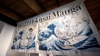 Manga Hokusai Manga -näyttelyn juliste roikkuu näyttelyn katosta.