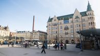 Ihmisiä kävelemässä Hämeenkadulla Jugendtorin edustalla. Taka-alalla näkyy vanhoja beigen värisiä rakennuksia.