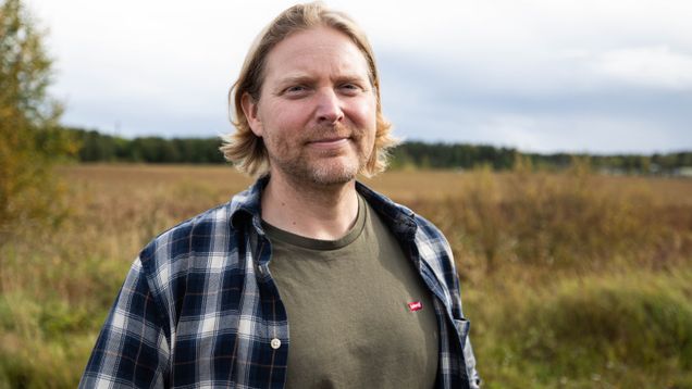 Joel Karlsson ler mot kameran med gulgrönt gräs i bakgrunden.