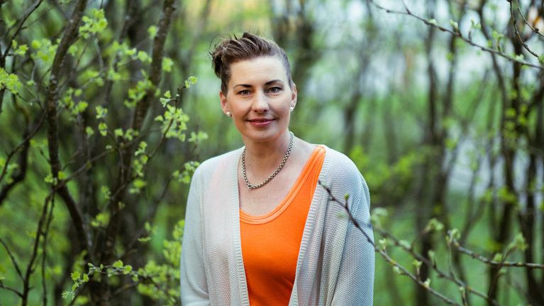 Bild av Jessica Hemming, en av Svenska Yles Sommarpratare 2026, framför växtlighet.
