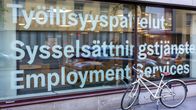 Polkupyörä nojaa ikkunaan, jossa lukee Työllisyyspalvelut kolmella kielellä: suomeksi, ruotsiksi ja englanniksi.