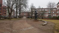 Salpapuisto Kouvolan keskustassa. Ilma on usvainen. Puistossa seisoo myös kirjailija ja toimittaja Unto Seppäsen patsas.