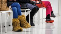 Sairaala Novan päivystyksen odotusaula. Kolmen ihmisen jalat, yhdellä on jalassaan näyttävät karvakengät.