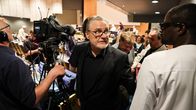 Mies kävelee väkijoukon keskellä Turun kaupunginvaltuuston kokouksen päätteeksi.