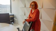 Person som står och lutar mot en stol 