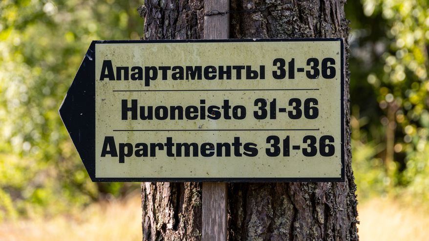 Suuntakyltti vanhan ja ränsistyneen leirikeskuksen alueella Suur-Miehikkälässä.