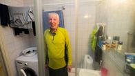 Timo nauraa kuvaajalle, joka käy ottamassa valokuvan suihkukaapin lasin läpi.