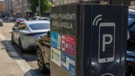 Pysäköintisovellusten mainoksia parkkilippuautomaatin kyljessä.